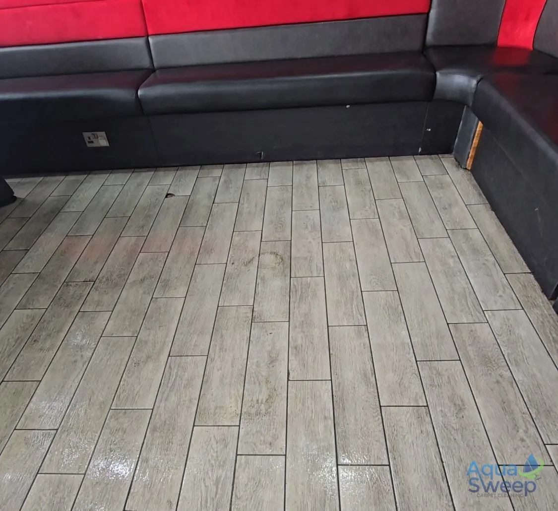Before: wood effect floor tiles in a bar seating area