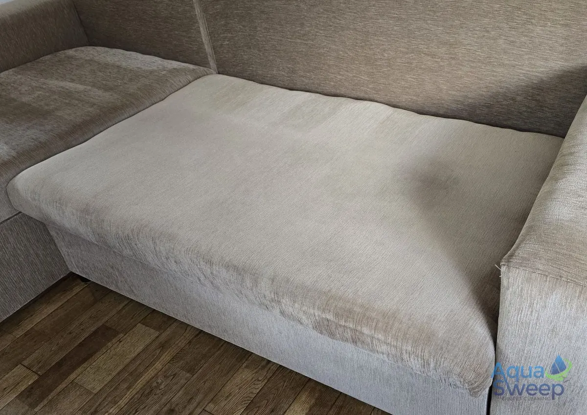 After: beige fabric corner sofa with a large dark stain across the chaise seat