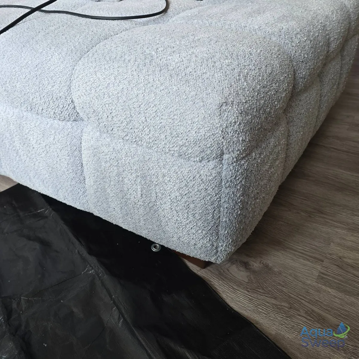 After: pale grey bouclé corner sofa with discoloured seat cushions