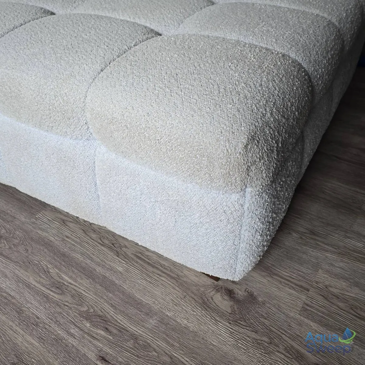 Before: pale grey bouclé corner sofa with discoloured seat cushions