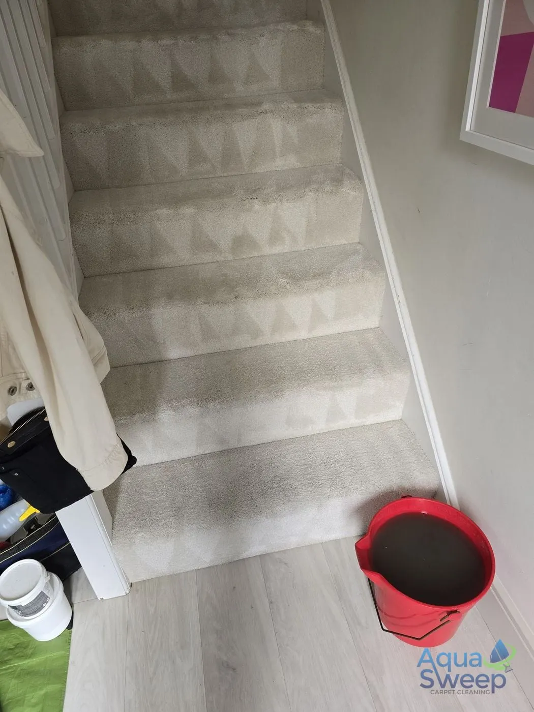 After: cream carpeted staircase with dark marks on every step