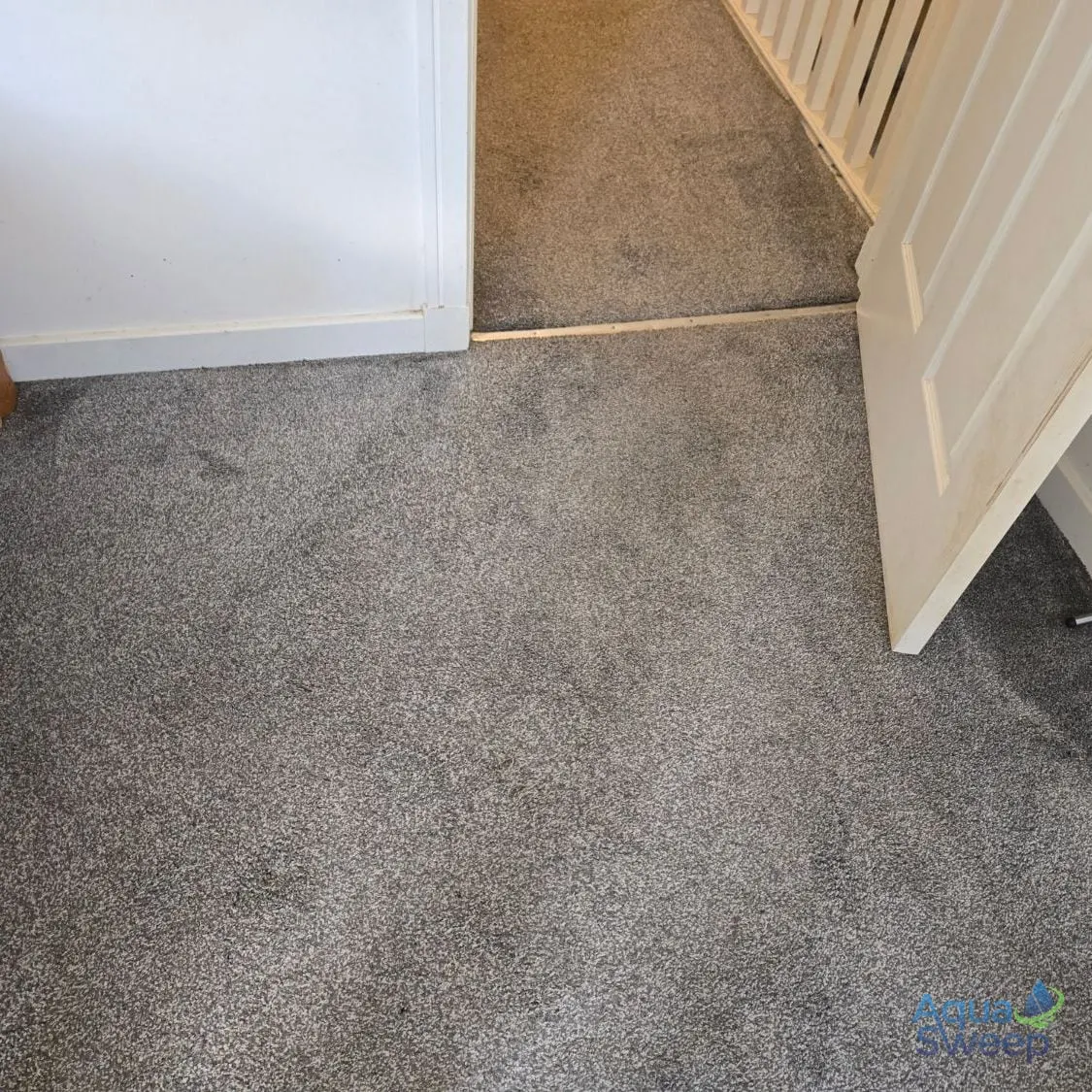After: grey bedroom carpet by the door with dark stains across it
