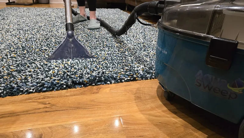 The AquaSweep hire machine cleaning a speckled blue rug