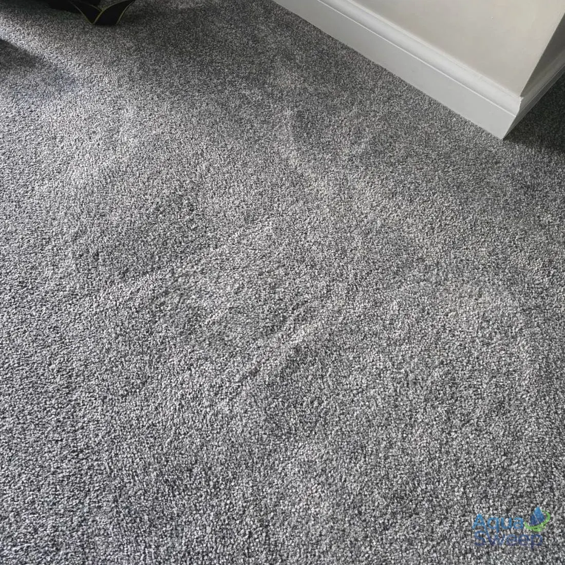 After: grey bedroom carpet with an iron shaped burn