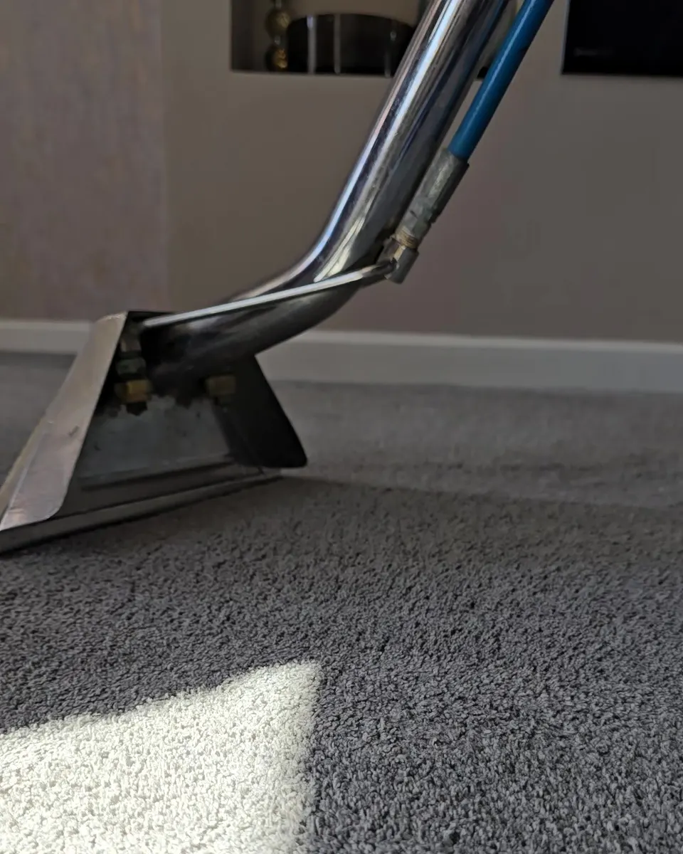 Cleaning wand rinsing a grey carpet and pulling the dirt back out